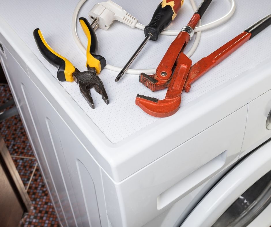 Appliance repair school tools set on a washer