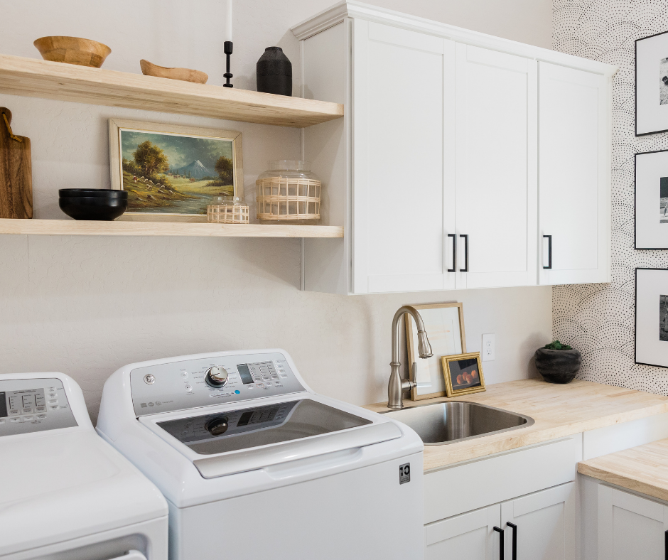 A clean and modern laundry room featuring a used washer and dryer alongside a stylish sink and shelving, emphasizing affordable appliance options.